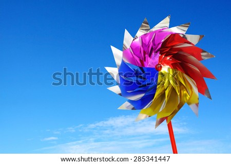 Colorful windmill toy against blue background