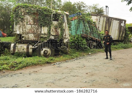 Policemen on a road with abandoned truck wreck at Quirigua on Guatemala, 24 january 2014