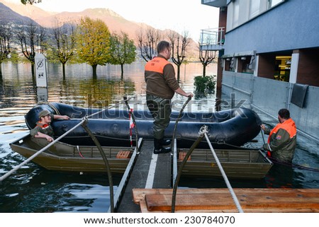 Locarno, Switzerland - 13 November 2014: People of civil protection with an inflatable boat in the flooded street of Locarno in Switzerland