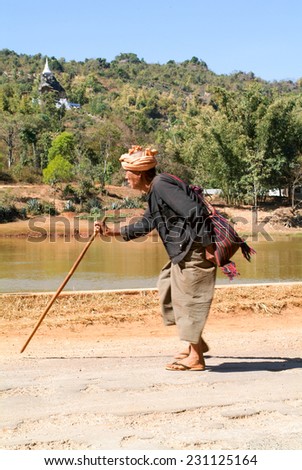 Pindaya, Myanmar - 13 January 2010: old man walking with a stick in the countryside of Pindaya on Myanmar