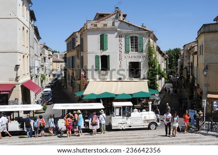 Arles, France -  27 June 2012: Tourists walking and taking the tourist train at Arles on France