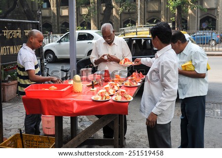 MUMBAI, INDIA- 5 January 2015: Vendor sells fruit salad in a street on Mumbai. According to the Food and Agriculture Organization, 2.5 billion people eat street food every day