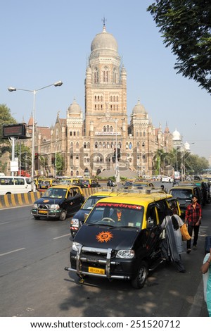 Mumbai, India - 5 january 2015: People getting on the taxi in front of a colonial Building at Mumbai, India