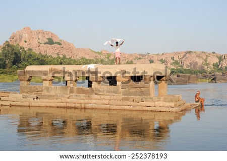 Hampi, India - 11 January 2015: People washing clothes and themselves in the river at Hampi on India