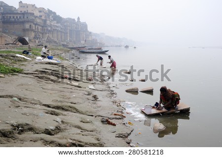 Varanasi, India - 27 January 2015: People washing clothes at ghats on the banks of Ganges river in holy city of Varanasi