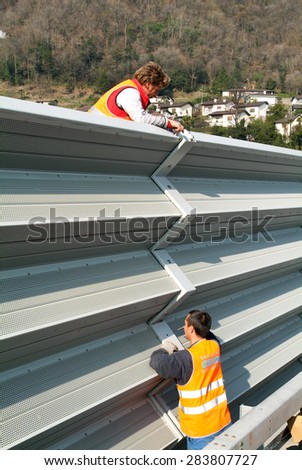 Bissone, Switzerland - 15 March 2007: Workers during the installation of noise barriers on the highway at Bissone on Switzerland