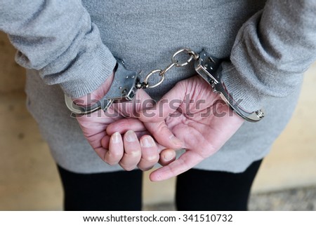 Arrested woman in handcuffs behind her back