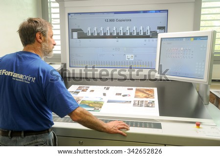 Lugano, Switzerland - 29 May 2013: Printer checking a print run at table