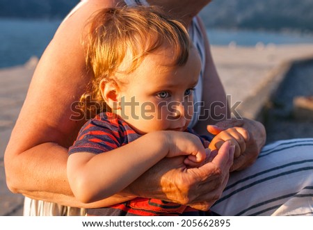 Portrait of a boy, whose grandmother hugs