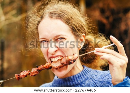 Woman eating shish kebab on picnic