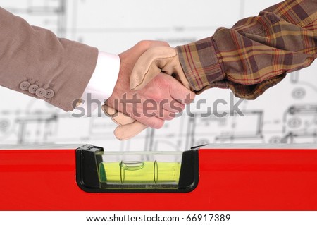 Worker and a businessman shaking hands over house renovation plans house renovation contract deal and plans
