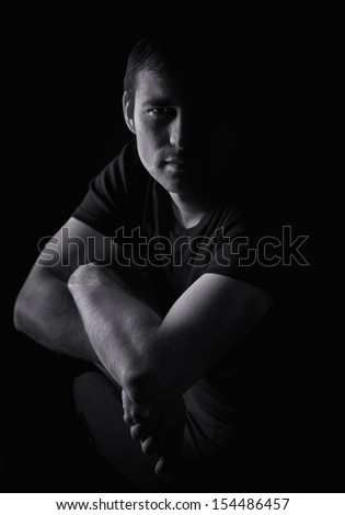 Black and white portrait of a young man. Dramatic studio lighting.