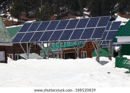 Solarcells generating electricity on a winter with snow mountain