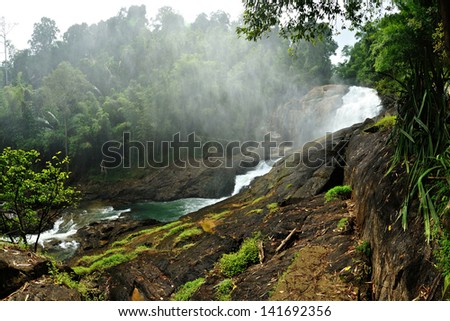 Water spray and mist rising from a large waterfall at National Park, Thailand.