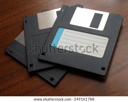 three floppy disk with blank label on wood table