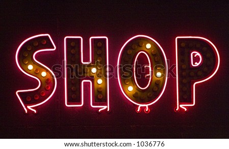 Neon shop sign with many of the lights blown out. The sign says Shop.