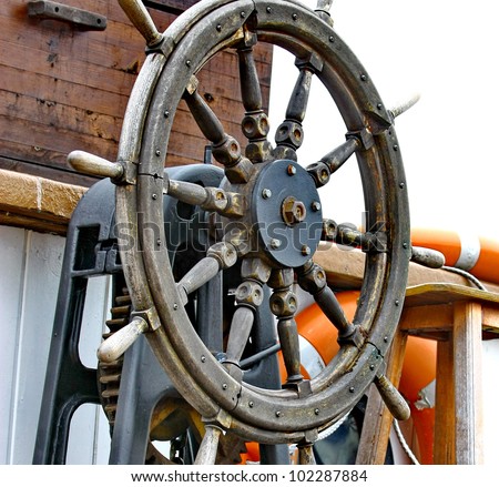 Close up of a steering wheel of the ship made of a wood