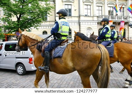 HELSINKI, FINLAND - JUNE 30: Mounted police protect people taking part in the annual Helsinki Pride gay parade in Helsinki, Finland on June 30, 2012.