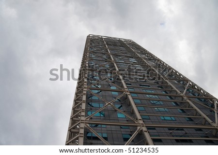 Modern sky scraper rising into the sky on a cloudy day
