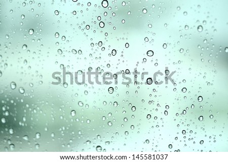 drops of rain on window with bokeh lights abstract