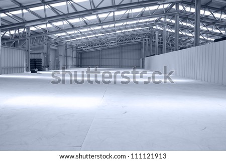Huge gray empty and light warehouse with metal roof
