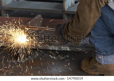 a shipyard steel worker burning steel