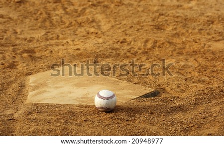 one baseball on home plate at a sports field