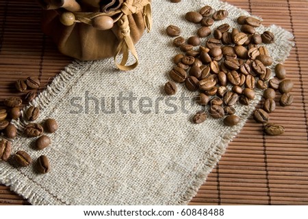 Background with roasted coffee beans and small leather pack