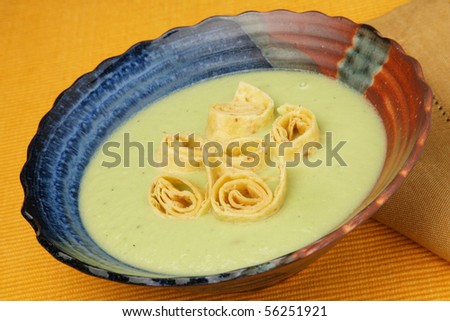 Delicious avocado soup with rolled pancakes