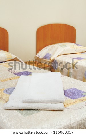 Hotel double room with a white towel on the bed