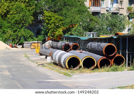 A stack of iron cast water supply pipes at construction site