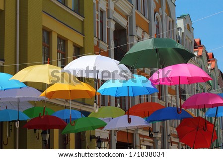 Colorful umbrellas hanging on the lines in sunny weather