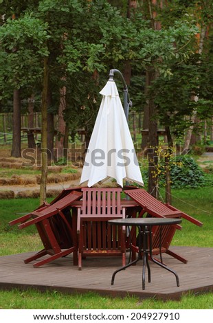 Folded chairs and umbrella of outdoor cafe