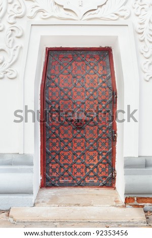 Vintage red metal door with a knock in the center