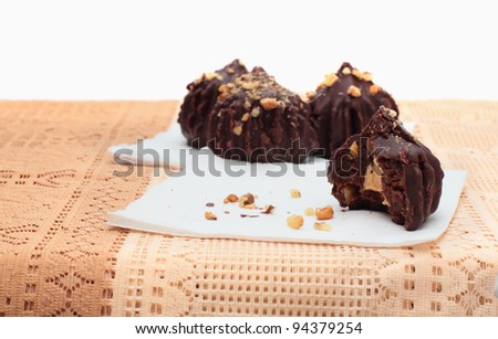 Bitten chocolate truffle cake with peanuts and another three on background