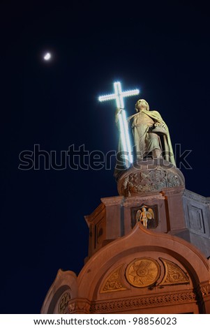 Monument of Vladimir the Great holding a glowing cross in Kiev, Ukraine