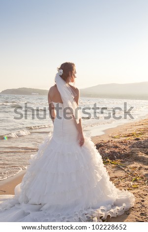 Bride in wedding dress at the beach at sunset