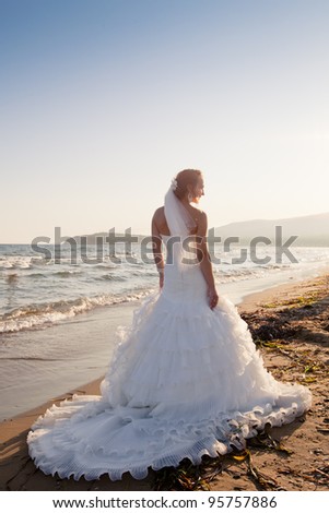 Bride in wedding dress at the beach at sunset