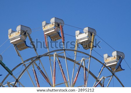 Empty ferris wheel chairs at the North Carolina State Fair set against a clear blue sky