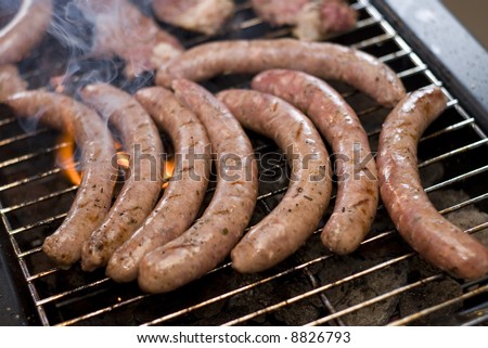 Barbecue sausage on grill with flame and smoke