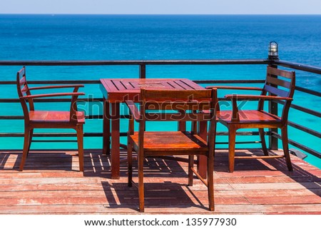 Terrace sea view with outdoor wood chairs and table in a luxury resort