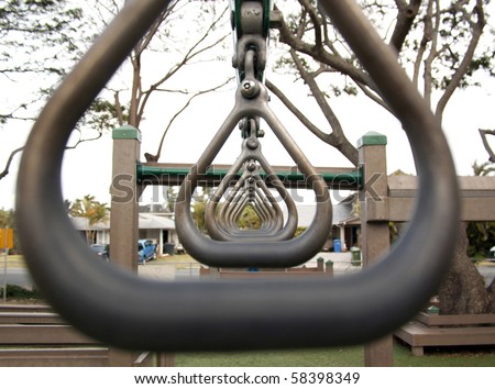 hanging rings of play equipment with playground in the background