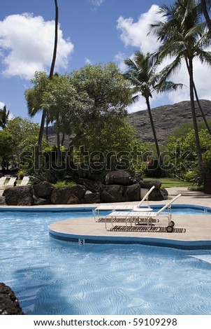 pair of white lounge chairs by a pool