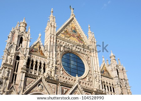 Facade of Siena Cathedral (Duomo di Siena) in Tuscan gothic style, Tuscany, Italy. This Cathedral is dedicated to Most Holy Mary of Assumption.