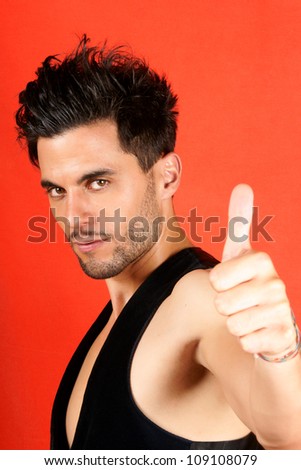 Smiling attractive 30 years old man with thumbs up over an orange background