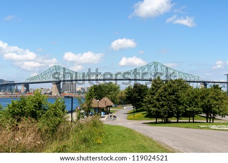 MONTREAL, CANADA - AUGUST 9: Jacques Cartier Bridge on August 9, 2008 in Montreal, Canada. View from Parc Jean Drapeau, on Saint Helen\'s Island. Some people walking or by bicycle in the park.