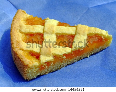 Slice of apricot jam tart on a blue paper napkin