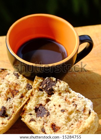 A cup of italian style black coffee and muffin with chocolate chips
