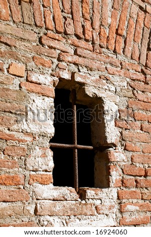 Ancient defense window on a fortress brick wall