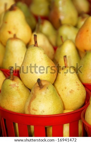 Ripe pears in red plastic baskets for sale at a fruit and vegetables open market